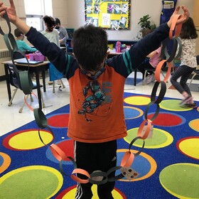 un élève avec son bricolage en carton